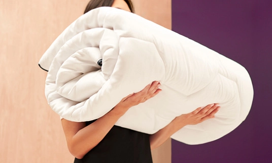 Femme portant une housse de couette propre et pliée