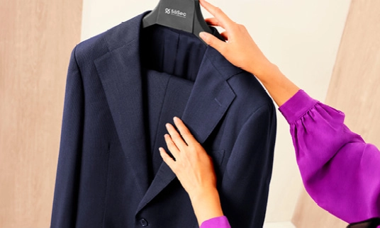 Femme en train de presser un blazer noir