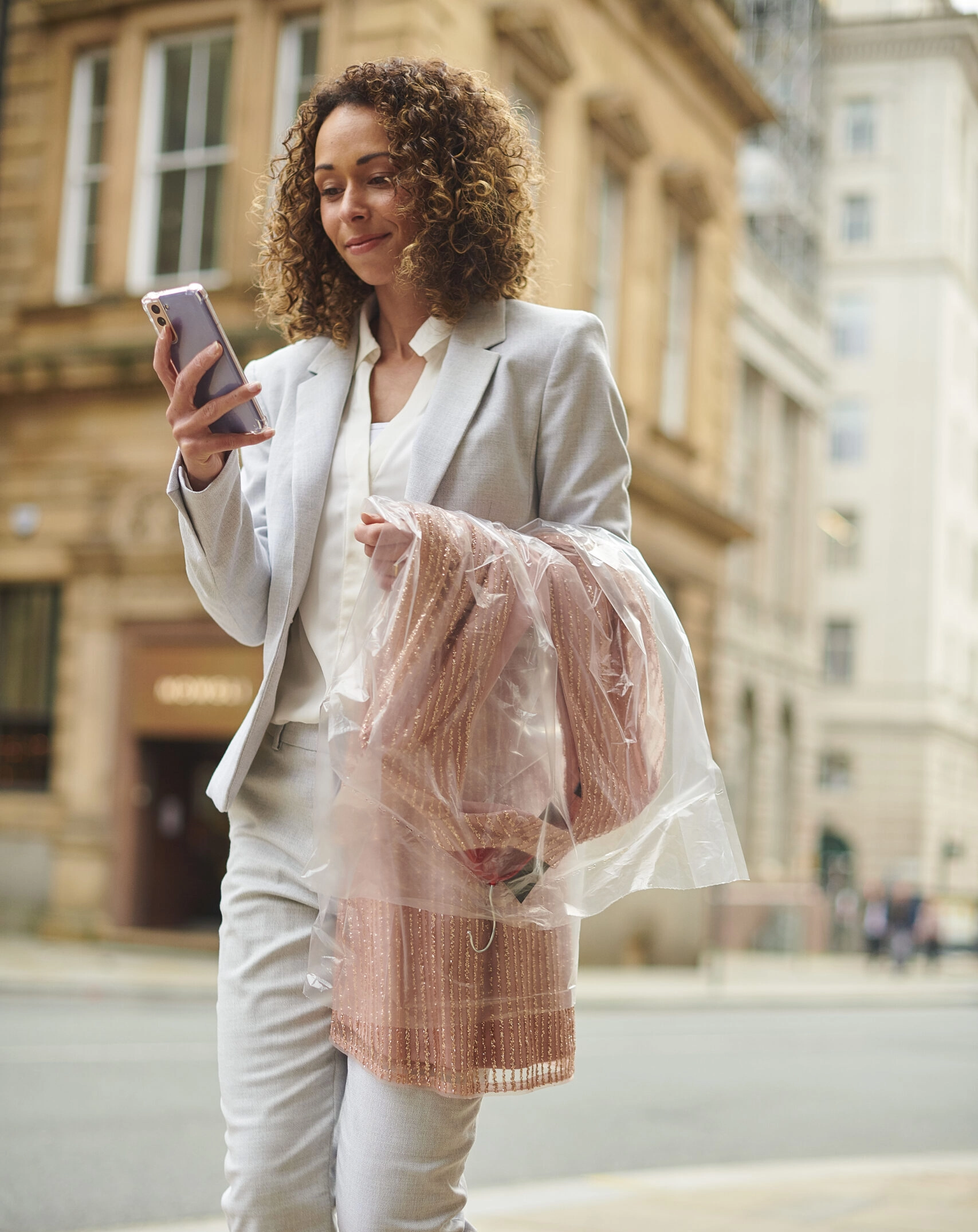 Professionnelle utilisant un service de conciergerie pressing entreprise avec vêtement protégé sous housse